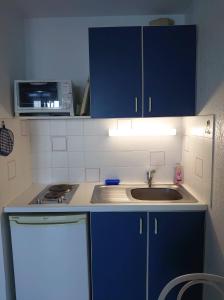 a kitchen with blue cabinets and a sink and a microwave at 4RB4 Appartement type T2 bord de mer ACCES PLAGE DIRECT in Collioure