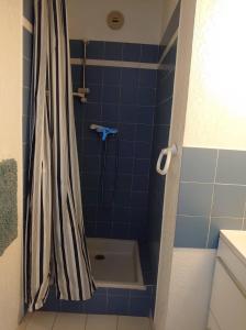 a blue tiled shower with a shower curtain in a bathroom at 4RB4 Appartement type T2 bord de mer ACCES PLAGE DIRECT in Collioure