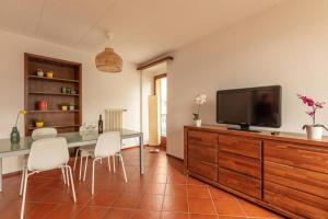 ein Wohnzimmer mit einem Esstisch und einem Flachbild-TV in der Unterkunft Casa al Sole - Bellissimo appartamento con terrazza e vista lago in Minusio