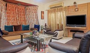 sala de estar con sofá y TV en Treebo Trend Excellent Home en Pune