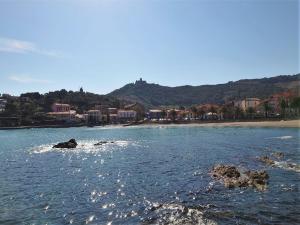 a body of water with a beach and buildings at 4RB4 Appartement type T2 bord de mer ACCES PLAGE DIRECT in Collioure