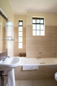 bagno con vasca bianca e lavandino di dreamplace bed and breakfast Gigiri a Nairobi