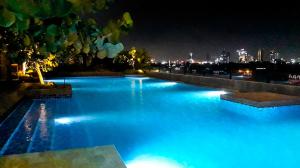 a large swimming pool with blue lighting at night at Ventura Room at TreePark City in Kebun Nanas