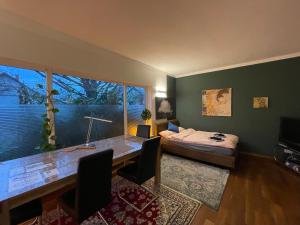 um quarto com uma secretária, uma cama e uma janela em Großes, helles Apartement - Nähe Marburg & Gießen em Fronhausen