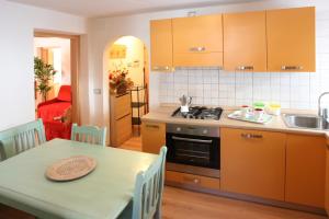 a kitchen with a table and a stove and a sink at Casa Lisa in Falcade