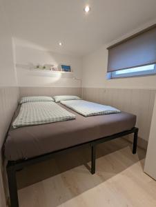 Łóżko w małym pokoju z oknem w obiekcie Ferienunterkünfte Zwischen Meer & See w mieście Bansin