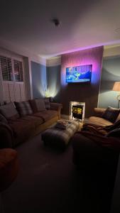 a living room with a couch and a fire place at ENAS COVE Homely Getaway in Derry Londonderry