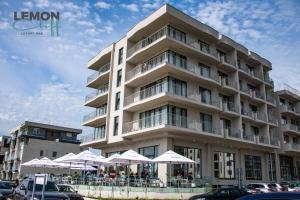 a large building with white umbrellas in front of it at Lemon Cliff Luxury B&B in Mamaia Sat/Năvodari