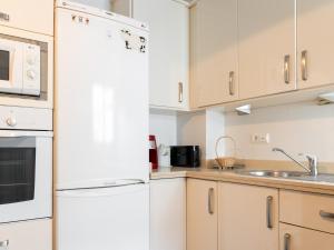 cocina con electrodomésticos blancos y nevera blanca en Apartamento céntrico Loyola, en Córdoba