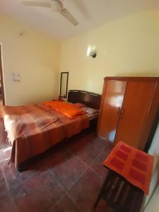 - une chambre avec un lit et une armoire en bois dans l'établissement Sukoon.Homestay, à Rājpur