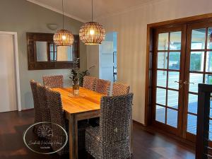 a dining room with a wooden table and chairs at Seashells Holiday House - Kalbarri in Kalbarri