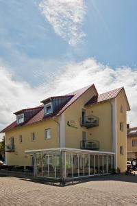 a large yellow building with a balcony at Gästehaus Kleeberger in Pleinfeld