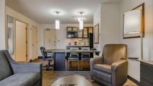 Sonesta Simply Suites Anaheim في أنهايم: غرفة معيشة ومطبخ مع طاولة وكراسي