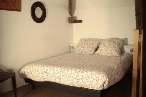 a bedroom with a bed with two pillows and a mirror at le clos des artistes - Gîte in Turny