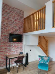 a living room with a brick wall and a table and chairs at The Northwick Arms Hotel in Evesham