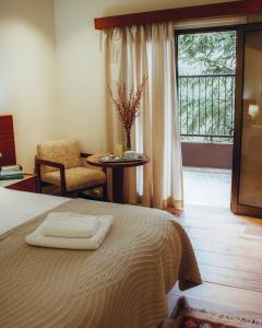 a bedroom with a bed with a table and a balcony at Kallithea INN in Platres