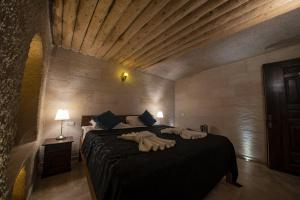 ein Schlafzimmer mit einem Bett mit zwei Handtüchern darauf in der Unterkunft Tabal Cave Hotel in Uchisar