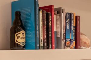 a bottle of beer sitting on a shelf with books at Bilbao Arte II by Aston Rentals in Bilbao