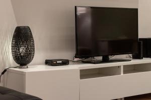 a flat screen tv sitting on a white entertainment center at Bilbao Arte II by Aston Rentals in Bilbao