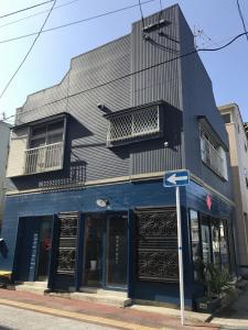 um edifício negro numa esquina com uma placa de rua em Golden Mile Apartment em Amami
