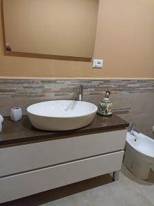 ein Badezimmer mit einem großen weißen Waschbecken auf der Theke in der Unterkunft Casa De Luca in Arnesano
