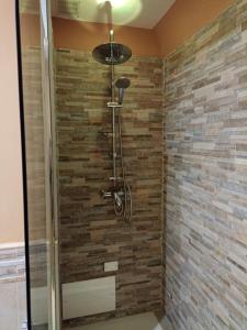 eine Dusche im Bad mit Ziegelwand in der Unterkunft Casa De Luca in Arnesano