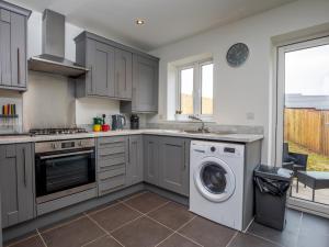 a kitchen with a washer and a washing machine at Pass the Keys Modern 2 bedroom home close to town with parking in Ludlow