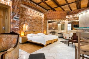 a bedroom with a bed and a brick wall at Aparthotel Stare Miasto in Kraków