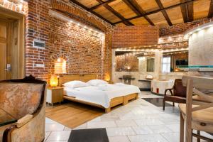 a bedroom with a bed and a brick wall at Aparthotel Stare Miasto in Krakow
