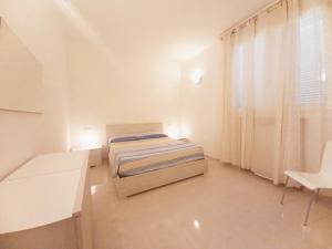 a bedroom with a bed and a desk and a window at Palau Fonte Vecchia apartments in Palau