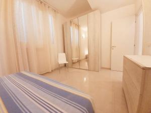 a white room with a bed and a mirror at Palau Fonte Vecchia apartments in Palau