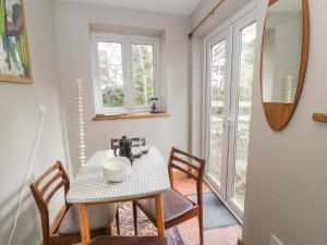 a dining room with a table and chairs and a mirror at 3 Alma Terrace in Llanfairfechan