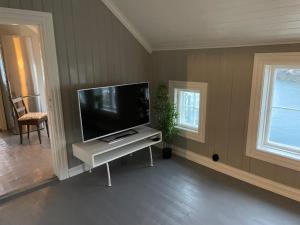 sala de estar con TV de pantalla plana en una mesa blanca en 2. etg i Dampskipsbrygga, Lødingen havn en Lødingen