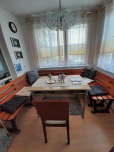 a dining room with a table and benches and windows at Haus Sorgenfrei in Caputh