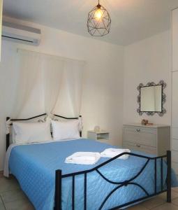 una camera con letto blu e specchio di Katerina & Joanna Adamas Studio Milos ad Adámas