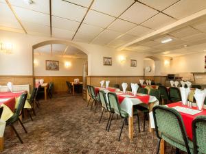 uma sala de jantar com mesas e cadeiras vermelhas e verdes em Oak Lea Hotel em Blackpool