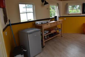 eine Küche mit einem kleinen Kühlschrank in einem Zimmer in der Unterkunft Happy Home-Slapen onder de sterren in Kronenberg