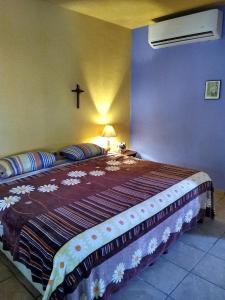 1 dormitorio con 1 cama con una cruz en la pared en Casa de Campo Tamasopo, en Tamasopo
