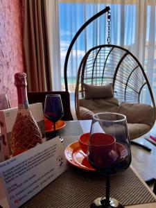 een tafel met twee glazen en een fles wijn bij Aqua Vista NUBA 5 - Vedere Top la Mare - Summerland in Mamaia