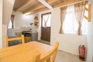 a kitchen with a wooden table in a room at El Pequeño Pajar in Majaelrayo