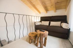 uma sala de estar com um sofá e dois bancos em El Pequeño Pajar em Majaelrayo