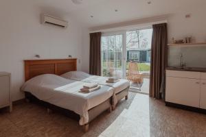 a bedroom with a bed and a large window at Ons Buiten in Oostkapelle