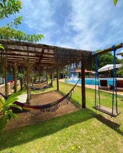 un columpio en un parque con piscina en Pousada o Casarão, en São Miguel dos Milagres