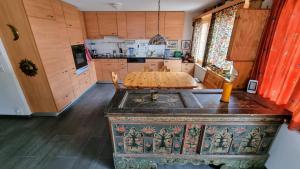 a kitchen with a wooden table and a kitchen with a sink at Snow+Surf B&B in Lauenen