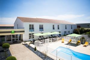 a hotel with a swimming pool and a building at ibis Styles Marennes d'Oléron in Marennes