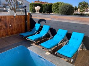 a group of blue lounge chairs next to a swimming pool at Jazmines 22 in Calpe