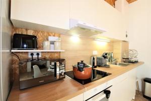 a kitchen with a toaster oven and a microwave at Les Bastidons de l'Isle - Le Saumane - 3 étoiles in LʼIsle-sur-la-Sorgue