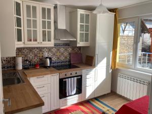 a kitchen with white cabinets and a stove top oven at Villa Rosa in Krayni Dol