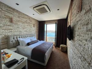 a bedroom with a bed and a brick wall at Weingart Port Seaside in Istanbul