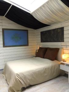 1 dormitorio con cama blanca y techo en À FLEUR D'EAU, en Sainte-Colombe-sur-lʼHers